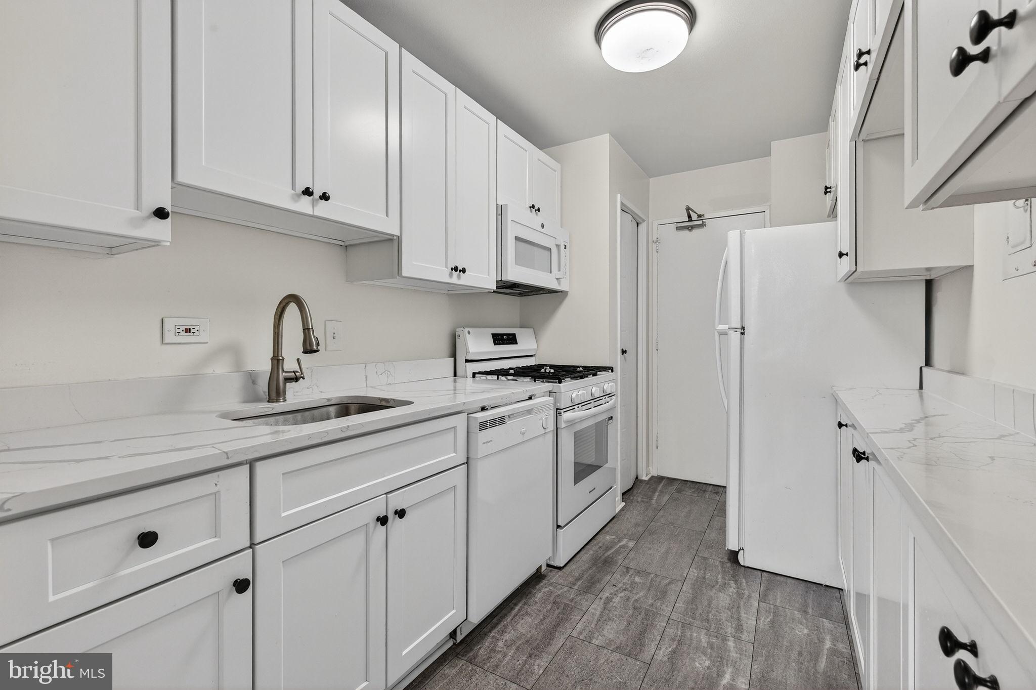 1900 Lyttonsville Road, Unit 618 Silver Spring, MD 20910 - Photo 14 of 36 Modern kitchen with sleek white cabinetry.
