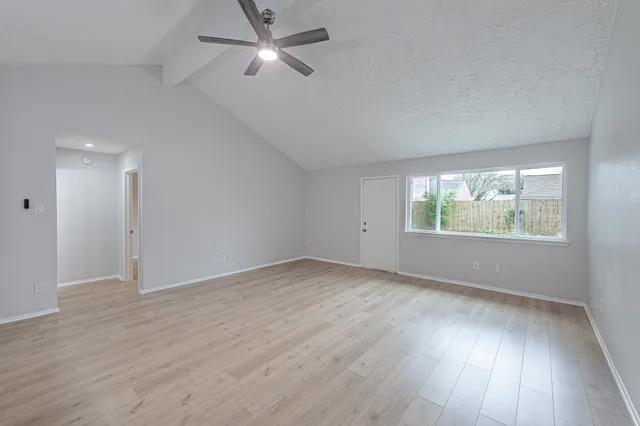 a large kitchen with a wooden floor and white stainless steel appliances