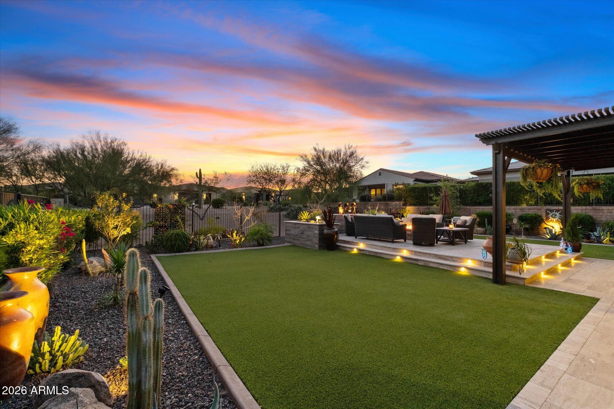 17561 Blaze Lane Rio Verde, AZ 85263 - Photo 32 of 46 a view of a swimming pool with lawn chairs and a dining table under an umbrella