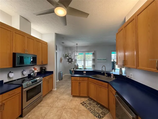 a kitchen with granite countertop a sink a counter top space appliances and cabinets