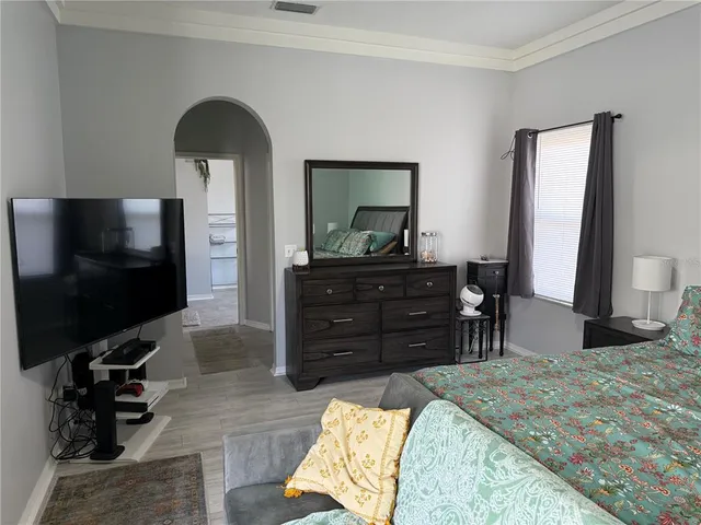 a bedroom with a bed and a flat screen television