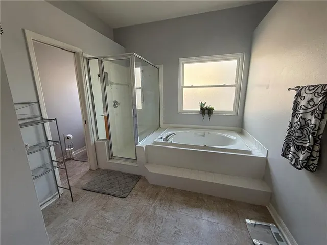 a spacious bathroom with a tub and a window