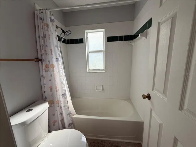 a white toilet sitting next to a bath tub
