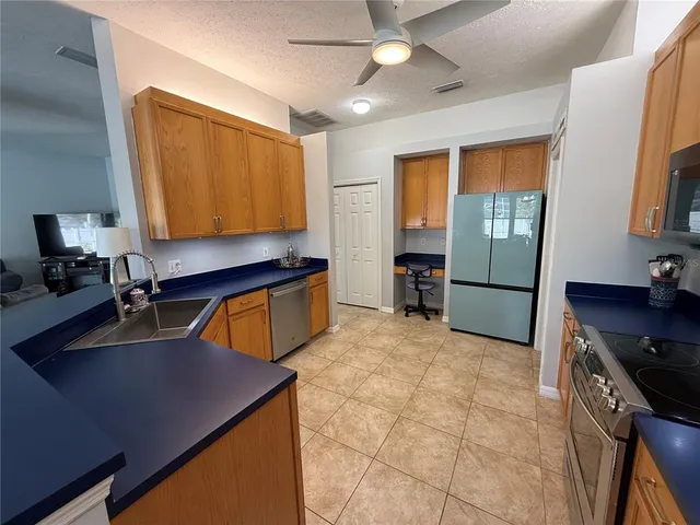 a kitchen with stainless steel appliances granite countertop a sink a stove and a refrigerator
