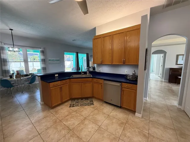 a kitchen with stainless steel appliances granite countertop a sink a stove cabinets and living room view