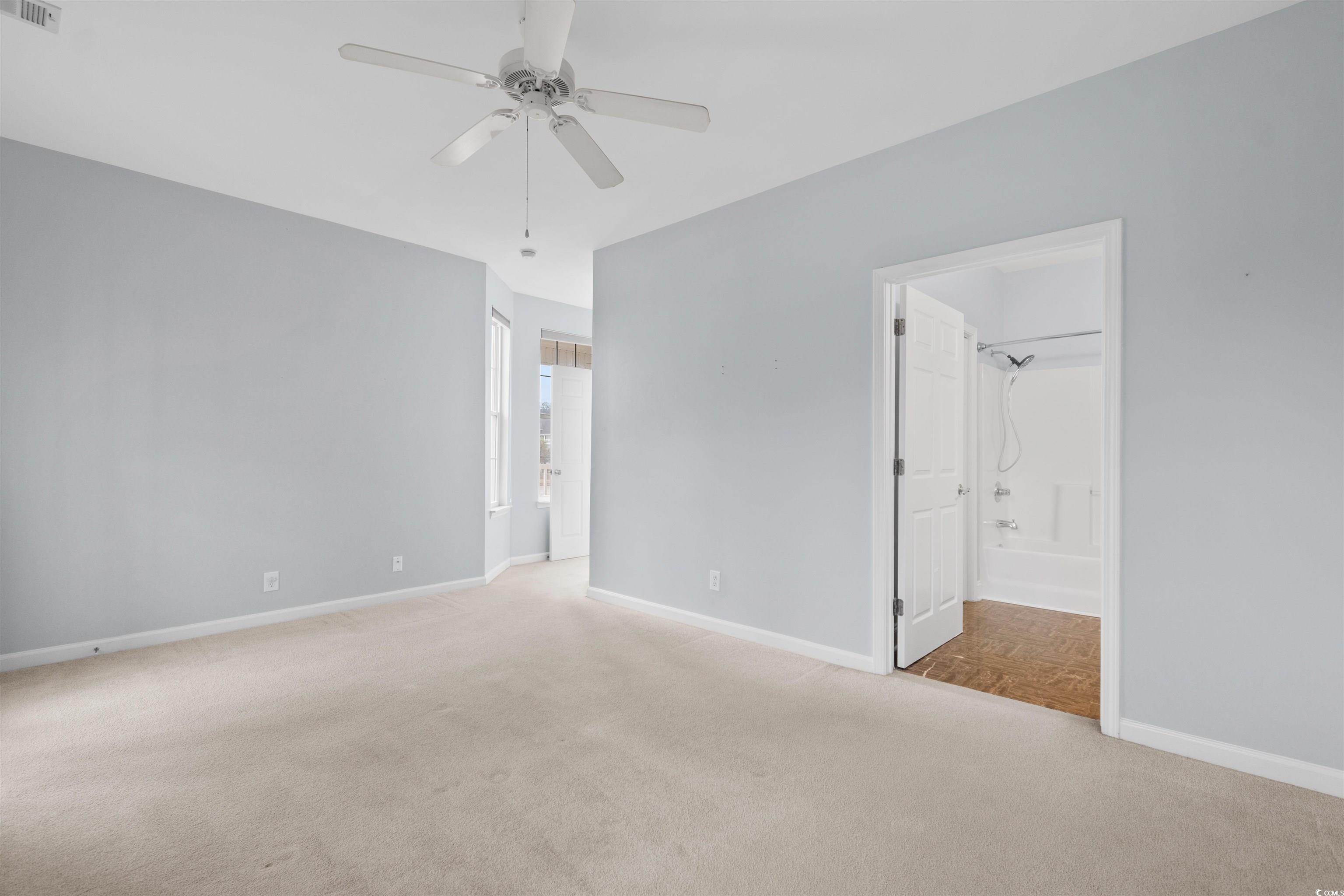 4430 Lady Banks Lane, Unit A2 Murrells Inlet, SC 29576 - Photo 19 of 31 Unfurnished bedroom featuring light carpet, a ceiling fan, and ensuite bathroom