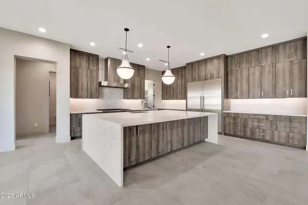 a living room with stainless steel appliances furniture and a flat screen tv