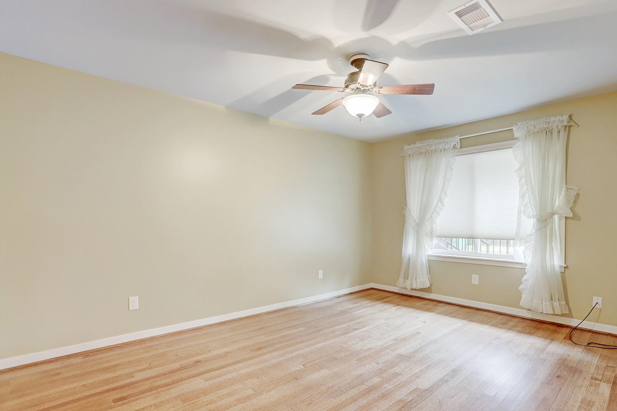 8019 Colgate Street Houston, TX 77061 - Photo 12 of 27 an empty room with wooden floor fan and windows