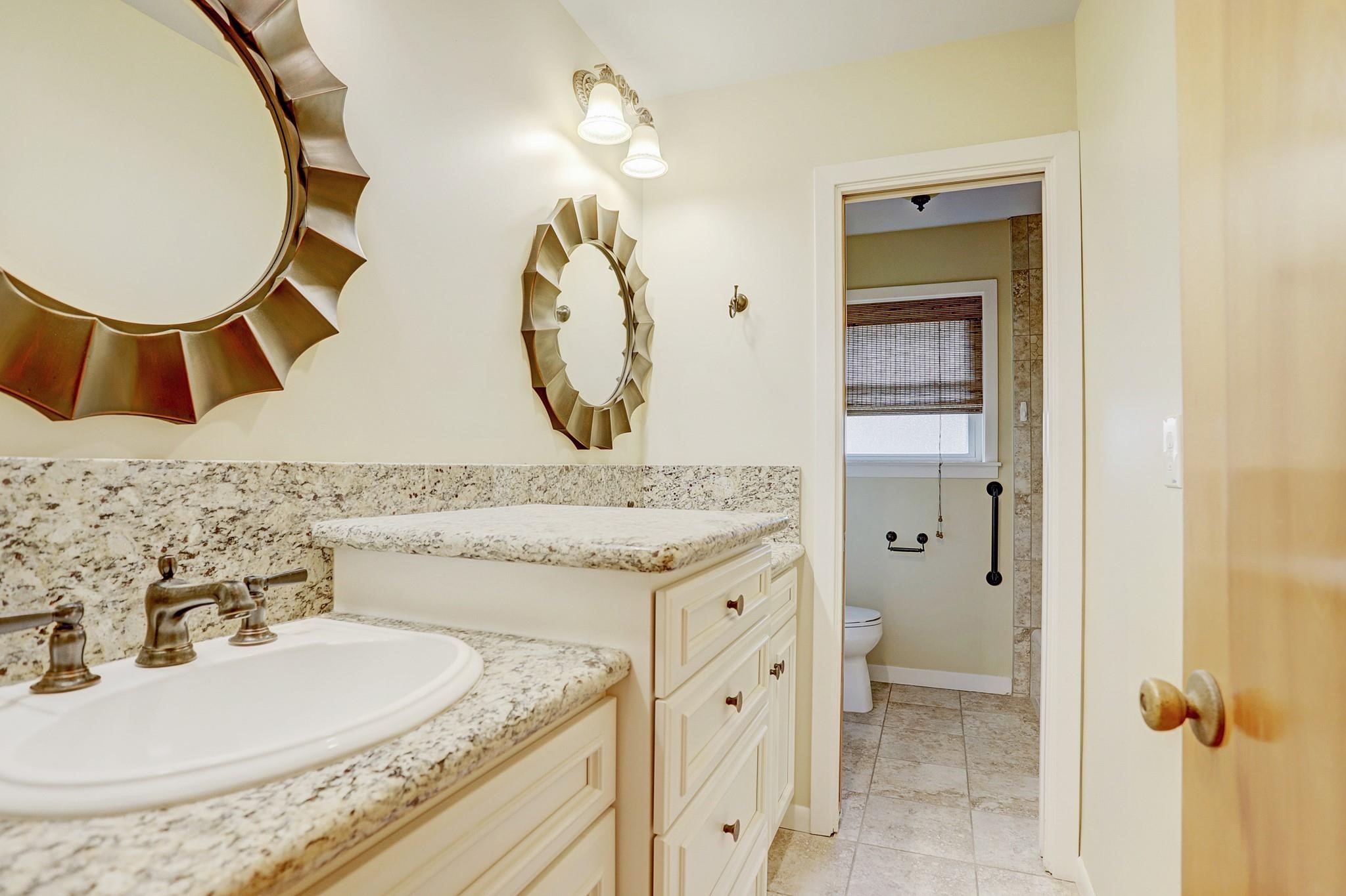 8019 Colgate Street Houston, TX 77061 - Photo 13 of 27 a bathroom with a granite countertop sink and a mirror
