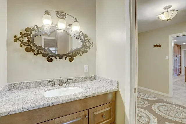 a bathroom with a granite countertop sink and a mirror