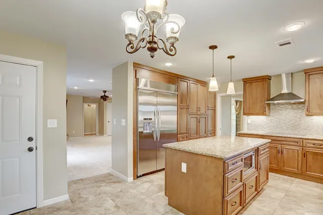 a kitchen with stainless steel appliances granite countertop a sink a stove and a refrigerator