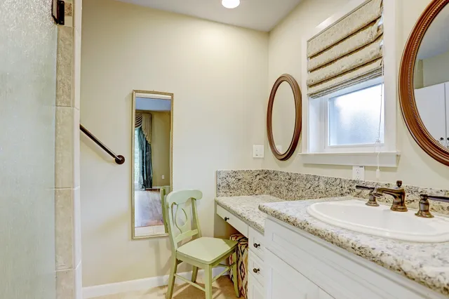a bathroom with a granite countertop toilet a sink and a mirror