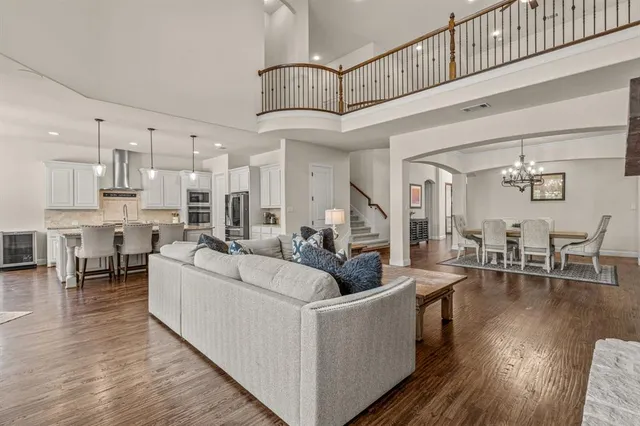 a living room with furniture a wooden floor and a chandelier