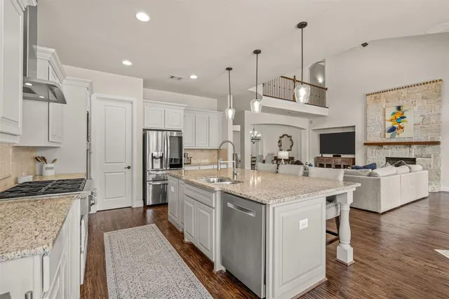 a kitchen with kitchen island white cabinets and refrigerator