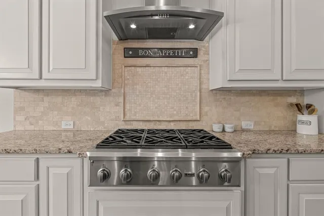 a kitchen with granite countertop a stove sink and cabinets