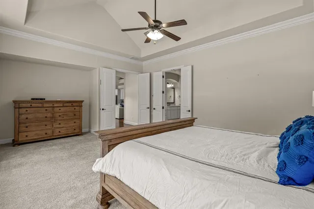 a bedroom with a bed and a ceiling fan