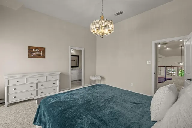 a bedroom with a bed and a chandelier