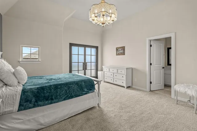a spacious bedroom with a bed and a chandelier