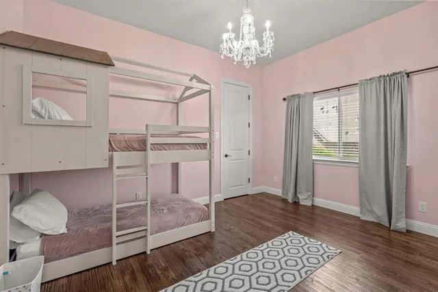 a spacious bedroom with a bed and wooden floor