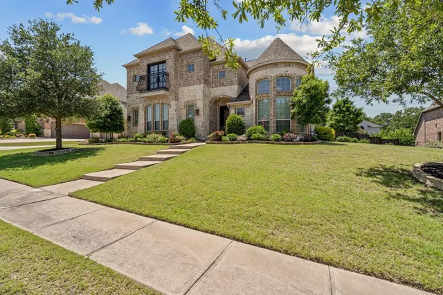 a front view of a house with a yard and trees