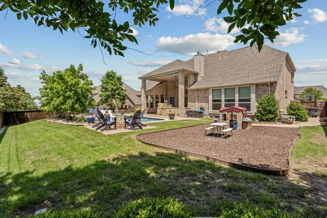 a view of a house with backyard and sitting area