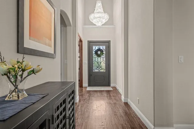 a view of a hallway with wooden floor and a potted plant