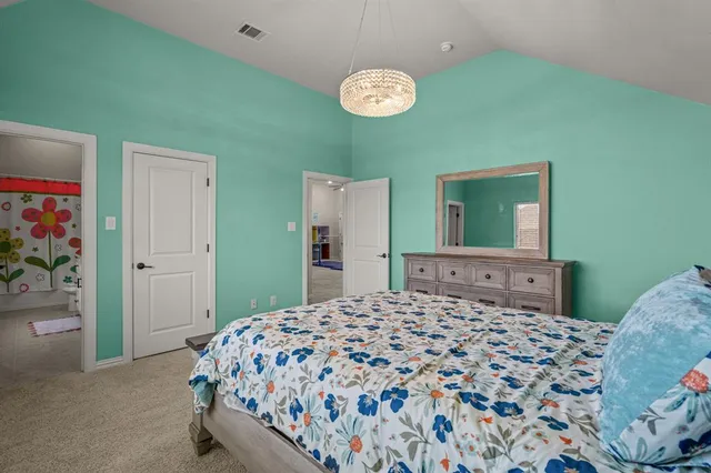 a bedroom with a large bed and a chandelier