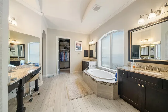 a bathroom with a tub sink a mirror and shower