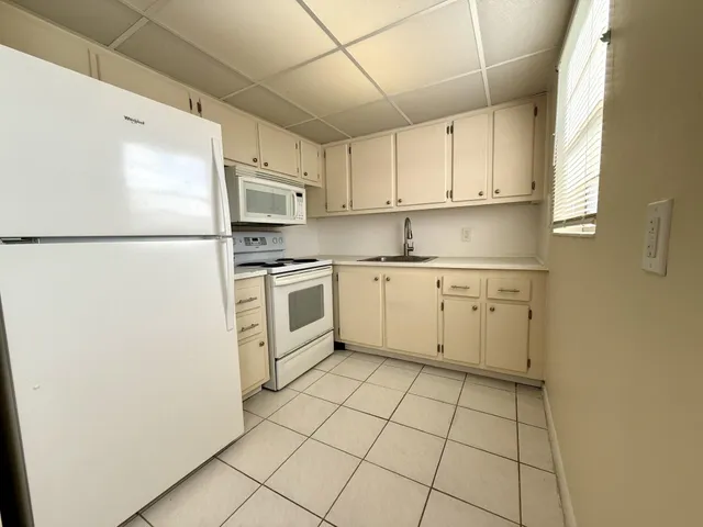 a kitchen with cabinets stainless steel appliances and a window