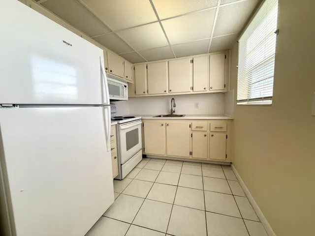 a kitchen with white cabinets and white appliances