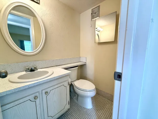 a bathroom with a toilet a sink and a mirror