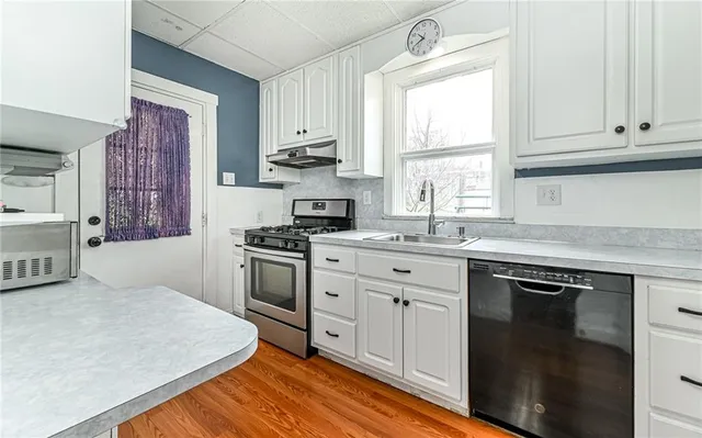 a kitchen with stainless steel appliances granite countertop a stove a sink and a microwave