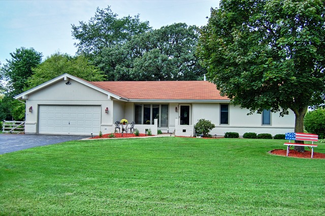 a view of a house with a yard and sitting area