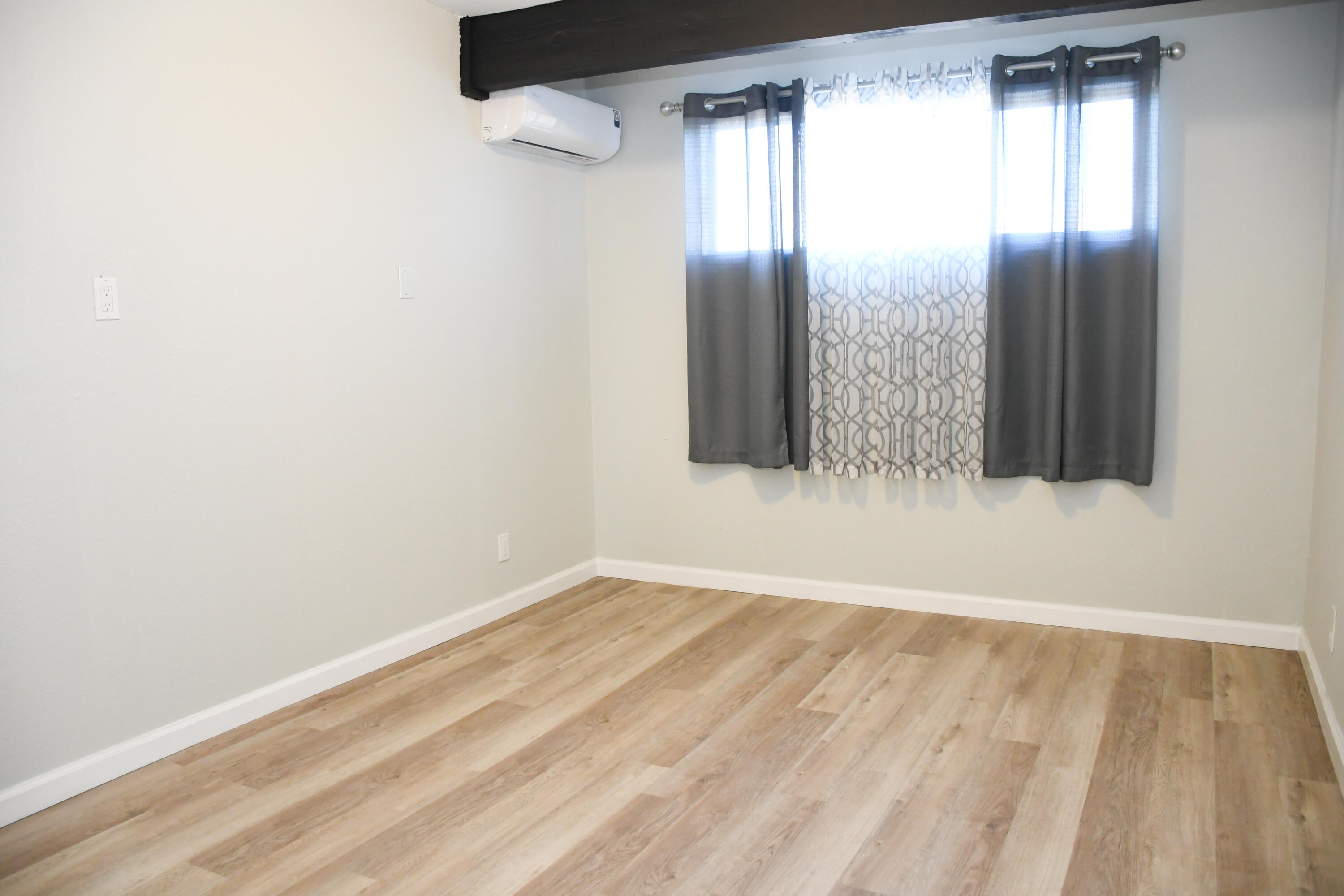 61576 Aberdeen Drive Joshua Tree, CA 92252 - Photo 13 of 31 a view of an empty room with wooden floor and a window