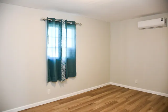 an empty room with wooden floor and closet