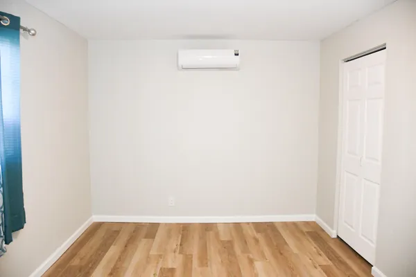 a view of a small space with wooden floor and a window