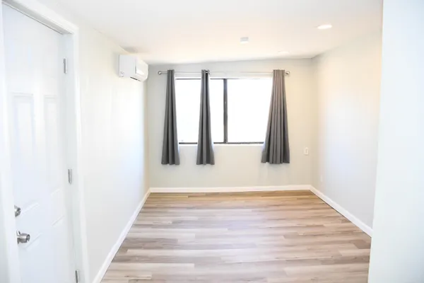 a view of an empty room with wooden floor