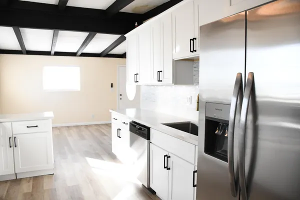 a kitchen with stainless steel appliances a refrigerator and a window