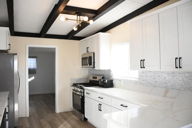 a kitchen with stainless steel appliances granite countertop a stove a sink and a refrigerator