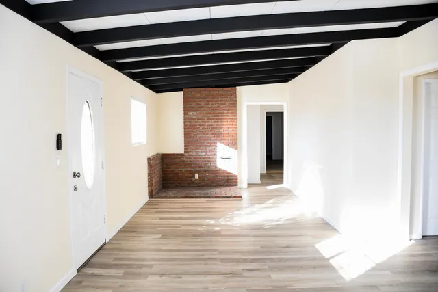a view of a hallway with wooden floor and staircase