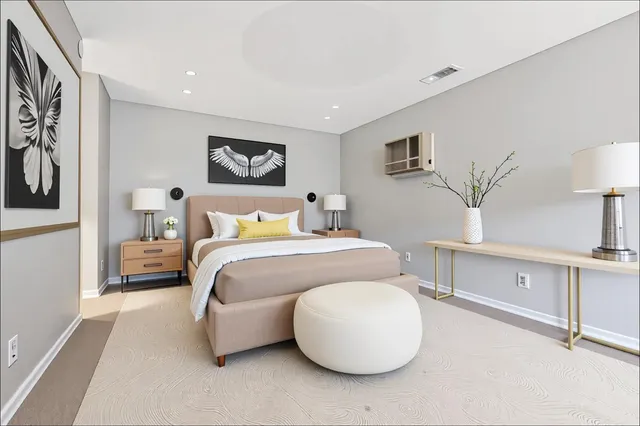 a bedroom with a bed and a lamp on dresser