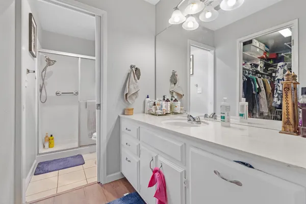 a spacious bathroom with a sink a mirror and a shower