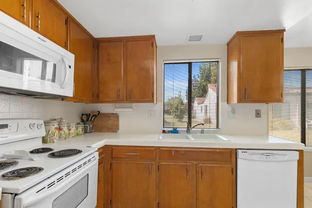 a kitchen with stainless steel appliances granite countertop a sink stove and cabinets