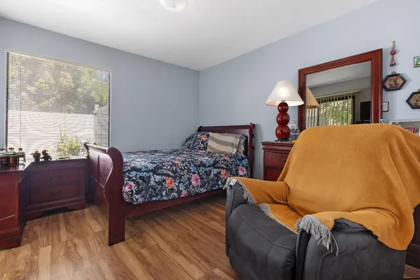 a bedroom with a bed and wooden floor