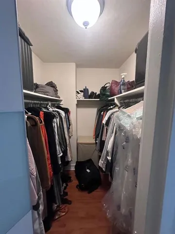 a view of walk in closet with clothes and shoes