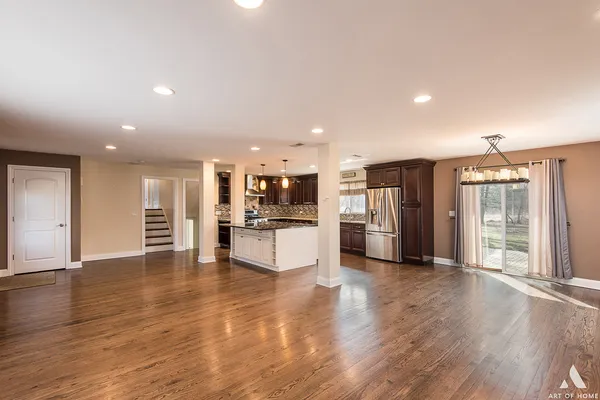 a view of a kitchen with stainless steel appliances wooden floor and a large window