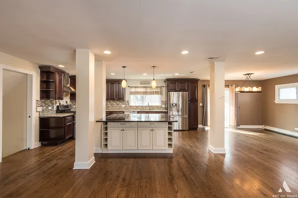 a kitchen with stainless steel appliances kitchen island granite countertop a stove top oven a refrigerator a sink and a oven