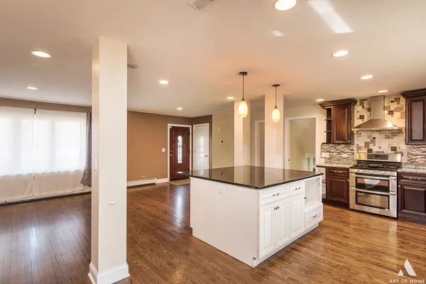 a kitchen with stainless steel appliances kitchen island granite countertop a stove and a refrigerator