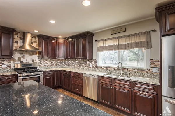 a kitchen with stainless steel appliances granite countertop a sink stove and cabinets