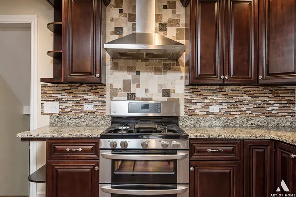 a kitchen with granite countertop a stove and a wooden cabinets